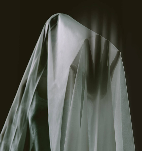 Das Übernatürliche berühren. Geisterhafte Erscheinung einer isolierten Frau auf schwarzem Hintergrund - Foto, Bild