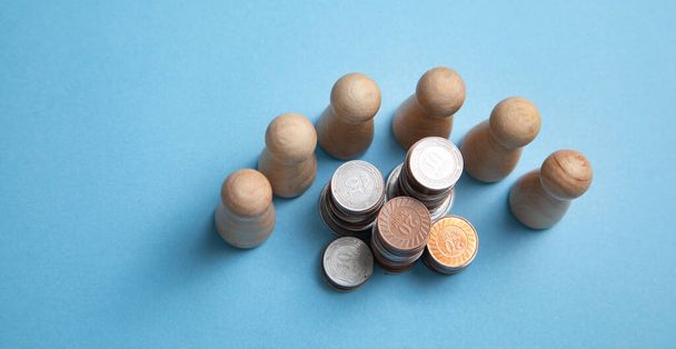 Wooden human figures with a stack of coins. - Foto, Imagem