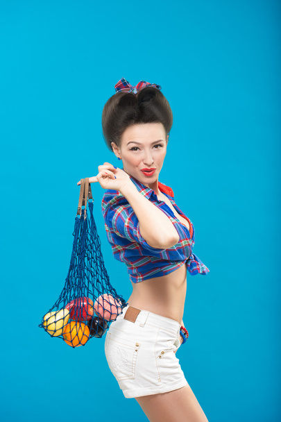 woman with pin-up make-up with a bag of fruit - 写真・画像