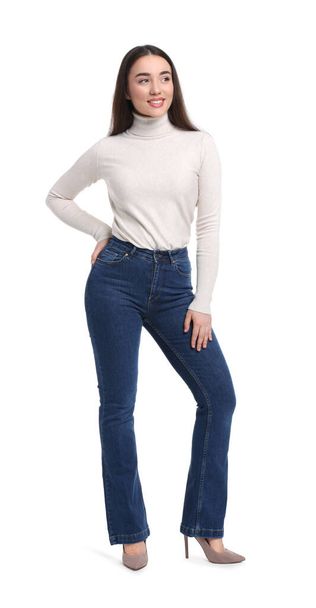 Young woman in stylish jeans on white background - Foto, Bild