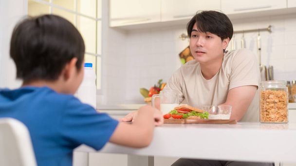 Young Asian father angry his son about eat vegetables in kitchen at home  - Foto, imagen