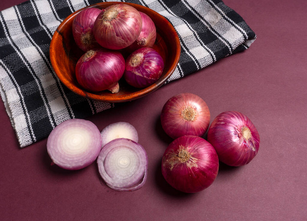 Zwiebeln in Schale und auf violettem Hintergrund - Foto, Bild