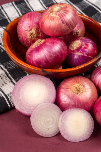 onions in bowl and on purple background - Photo, Image