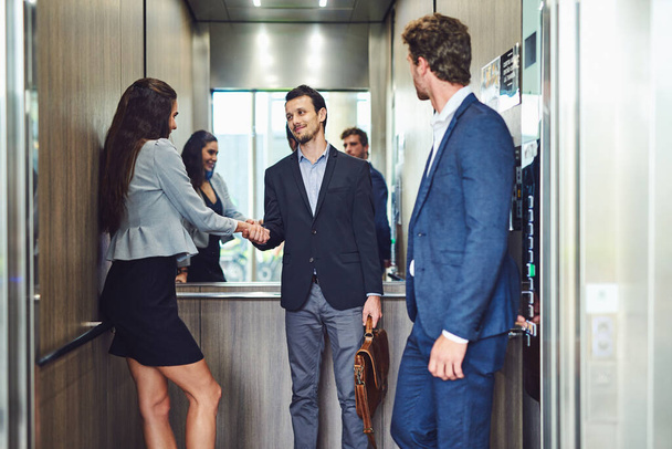 Aufs Parkett gehen. Geschäftsleute treffen sich und begrüßen sich im Fahrstuhl - Foto, Bild