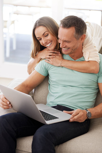 Doing a little bit of bonding and browsing. a couple using a laptop at home - Photo, image