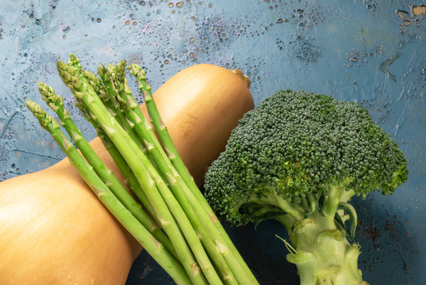 Friss brokkoli spárga vajdió tök zöldség kék fa háttér másolás hely, felülnézet, egészséges étel koncepció. - Fotó, kép