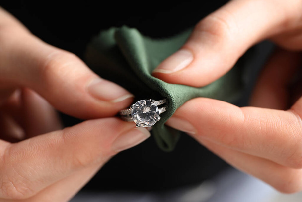 Jeweler cleaning diamond ring with microfiber cloth, closeup - Fotó, kép