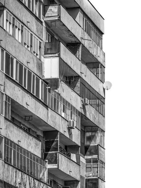 Zniszczony budynek mieszkalny z czasów komunizmu przeciwko błękitnemu niebu w Bukareszcie Rumunia. Brzydki, tradycyjny komunistyczny zespół mieszkaniowy. Czarno-białe abstrakcyjne fotografie. - Zdjęcie, obraz