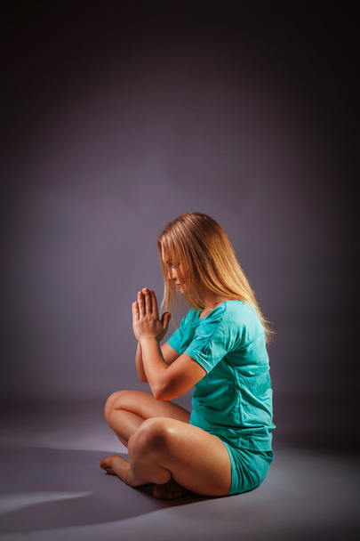 lány-szőke európai megjelenése kék melegítőben meditál a - Fotó, kép