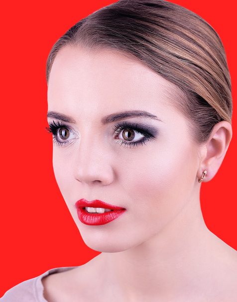 Portrait of young woman, on red background - Fotó, kép