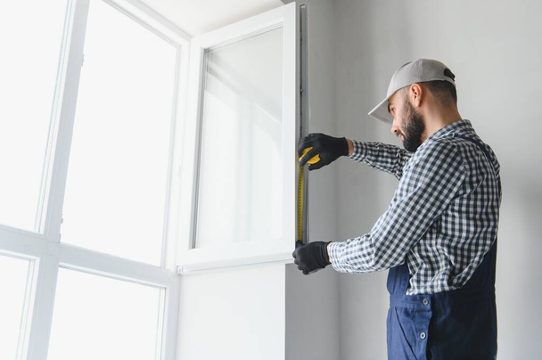 Construction worker installing window in house. - Foto, Imagen
