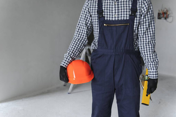 Builder handyman with construction tools. House renovation background - Foto, afbeelding