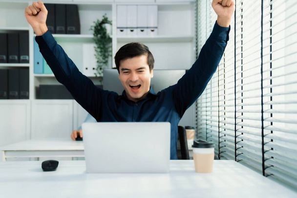 Young male employee receives a promotion, good news or finished his task and overjoyed for being a competent worker. Idea of promotion in career, reward for working hard worker. - Foto, Imagen