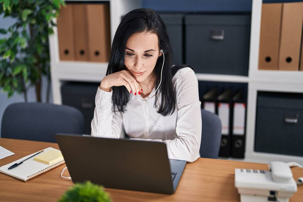 Jovem mulher caucasiana empresária usando laptop e fones de ouvido trabalhando no escritório - Foto, Imagem