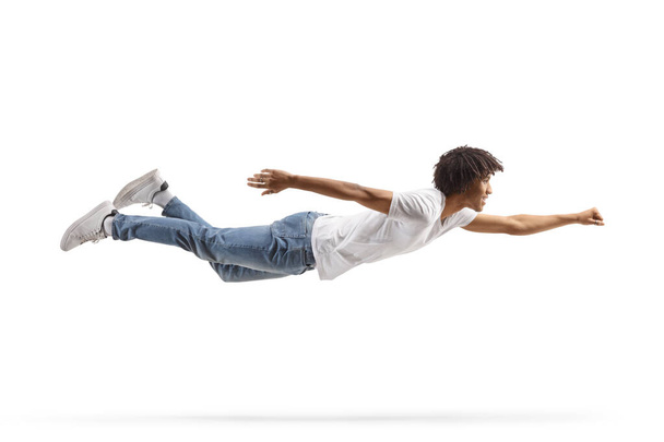 African american guy in jeans and white t-shirt flying isolated on white background - Zdjęcie, obraz