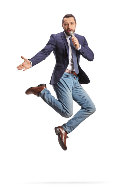 Excited man with a microphone jumping and singing isolated on white background - Foto, Bild