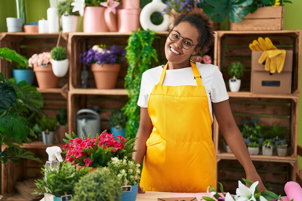 donna afroamericana fiorista sorridente fiducioso in piedi al negozio di fiori - Foto, immagini
