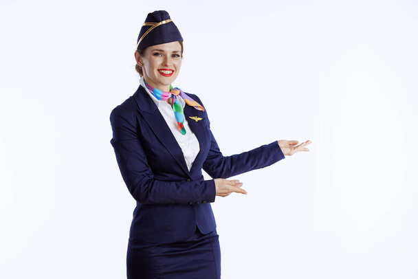 happy stylish female flight attendant against white background in uniform welcoming. - Foto, afbeelding