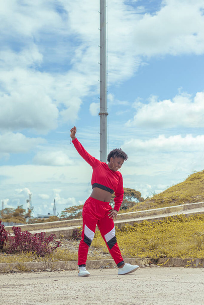 Jover mujer afro realizar baile estilo urbano en parque local con hermoso y grande cielo y vegetacion. - Foto, Imagen
