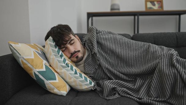 Νεαρός Ισπανός ξαπλωμένος στον καναπέ και κοιμάται στο σπίτι. - Φωτογραφία, εικόνα