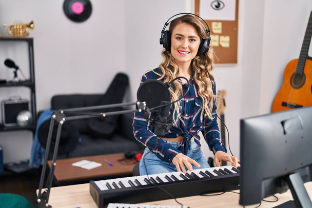 Young woman musician playing piano keyboard at music studio - Zdjęcie, obraz