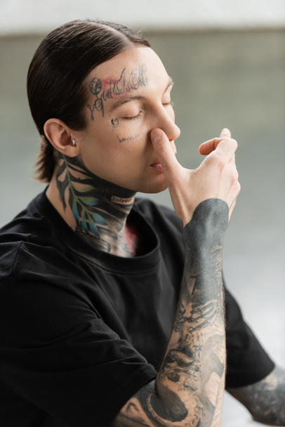 Tattooed man practicing nostril breathing and meditation in yoga class  - Photo, Image