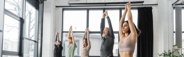 Personnes interraciales pratiquant la pose Crescent Lunge dans un studio de yoga, bannière  - Photo, image