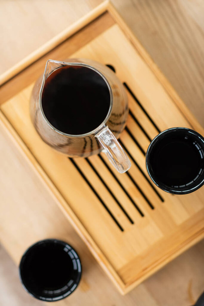 top view of brewed puer tea in glass jug near Japanese cups  - Fotografie, Obrázek