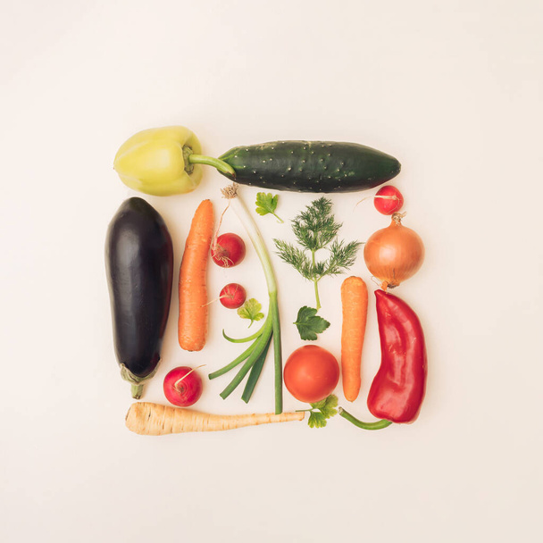 Arrangiert buntes Gemüse in einem Quadrat auf weißem Hintergrund. Flache Lage. - Foto, Bild