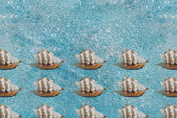 A wooden sailboat ship on a blue towel. Pattern. - Фото, изображение