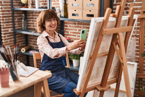 Mulher de meia idade artista fazer foto para desenhar por smartphone no estúdio de arte - Foto, Imagem