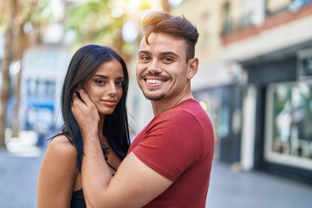 Uomo e donna coppia sorridente fiducioso abbracciarsi in strada - Foto, immagini