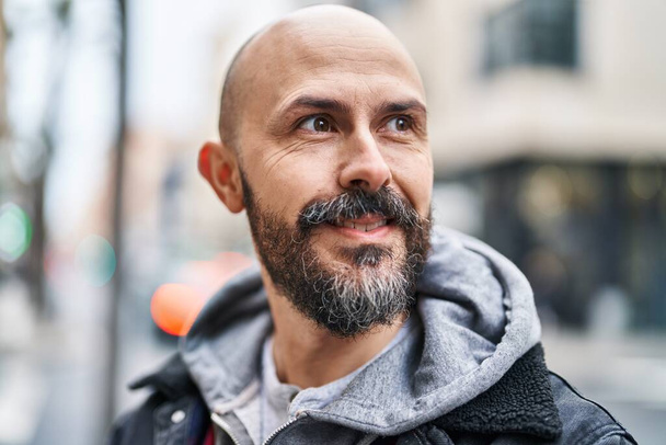 Young bald man smiling confident looking to the side at street - Photo, Image
