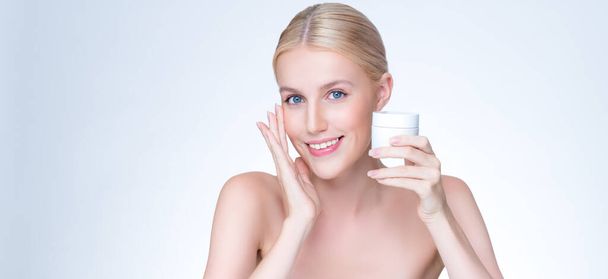 Personable piękne naturalne skóry kobieta trzymać mockup słoik krem nawilżający do pielęgnacji skóry leczenie reklama produktu w izolowanym tle z ekspresyjnym wyrazem twarzy i gestu. - Zdjęcie, obraz