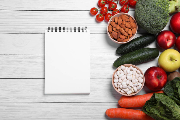 Notebook. fresh fruits and vegetables on white wooden table, flat lay. Low glycemic index diet - Fotó, kép