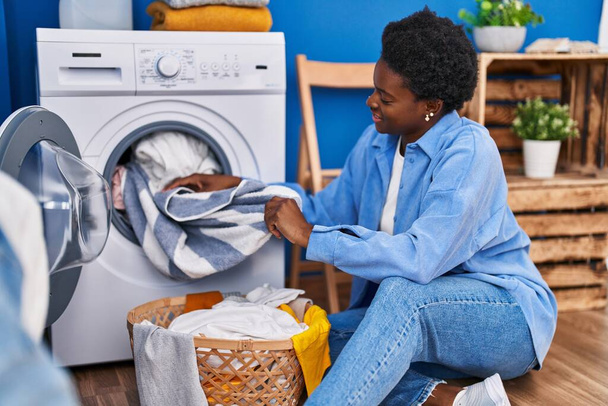 Afrikai amerikai nő mosolygós magabiztos a mosógép a mosókonyhában - Fotó, kép