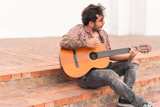 Латинский человек играет на акустической гитаре - Фото, изображение