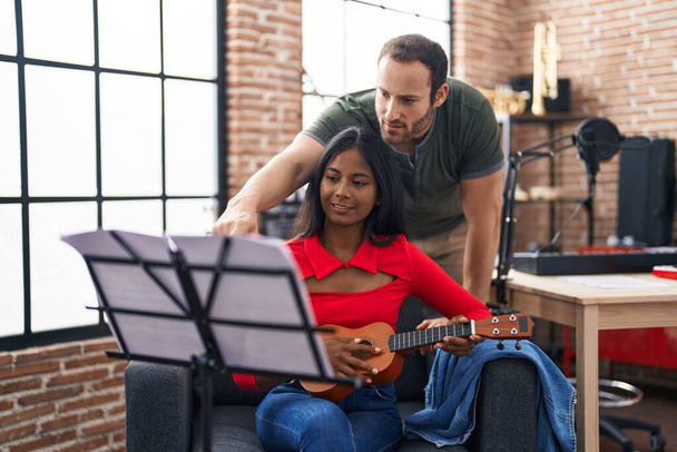 Mężczyzna i kobieta muzycy grają ukulele w studio muzycznym - Zdjęcie, obraz