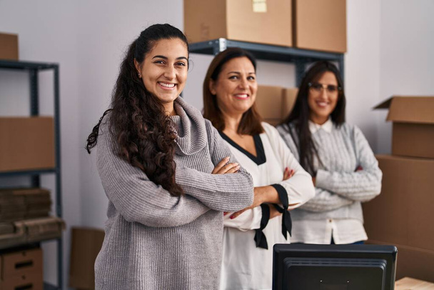 Tres mujeres de comercio electrónico trabajadores de negocios de pie con los brazos cruzados gesto en la oficina - Foto, Imagen