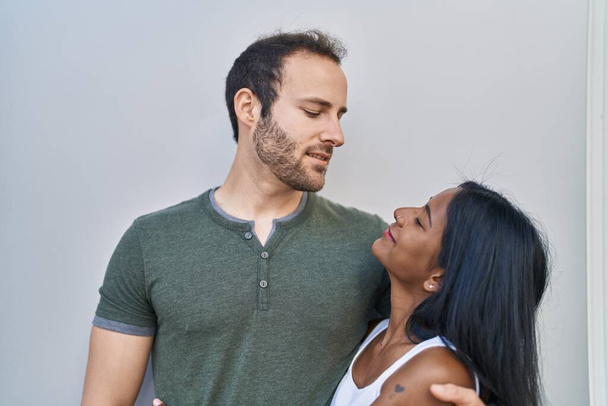 Man and woman interracial couple hugging each other over white background - Fotografie, Obrázek