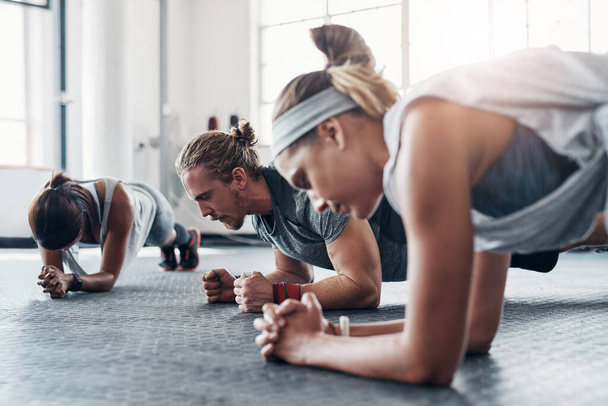 Dont you dare give up. an accountability group doing pushups at the gym - Zdjęcie, obraz