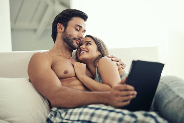 Is this what were doing today. an affectionate young couple relaxing on the sofa with a tablet - Foto, Imagem