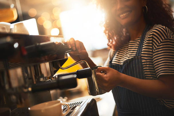 Tu cerveza perfecta está en camino. Primer plano de un barista operando una máquina de café en un café - Foto, Imagen