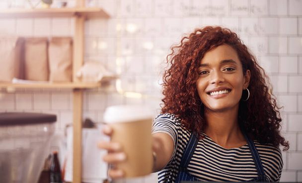Valorarás este café como tu favorito. Retrato de un joven camarero sosteniendo una taza de café en un café - Foto, imagen