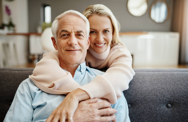 She holds the key to my heart. a mature woman hugging her husband on the sofa at home - Foto, Imagen