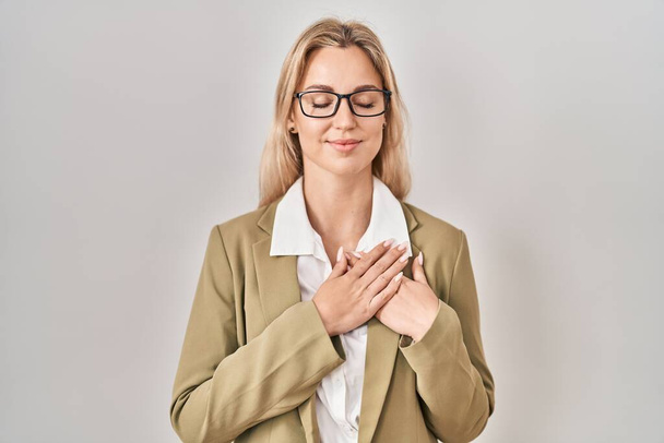 Young caucasian woman wearing glasses smiling with hands on chest with closed eyes and grateful gesture on face. health concept.  - Fotoğraf, Görsel