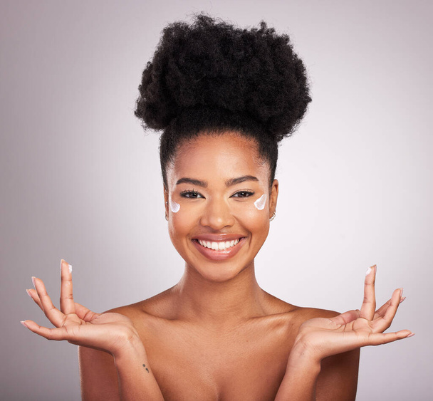 Black woman, moisturizer cream and smile for skincare beauty or cosmetics against a gray studio background. Portrait of happy African female smiling with moisturizing creme, lotion or facial product. - Фото, изображение