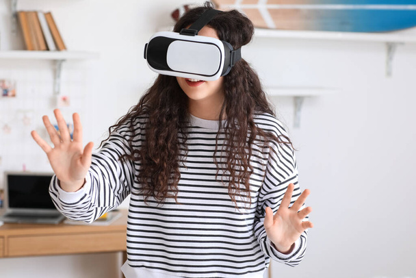 Teenage girl in VR glasses at home - Foto, Imagen