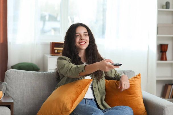 Девочка-подросток смотрит телевизор дома - Фото, изображение