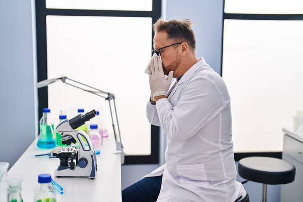 Young caucasian man scientist using napkin at laboratory - Φωτογραφία, εικόνα